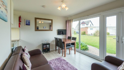 The sitting room/diner in one of the Hickling Chalets