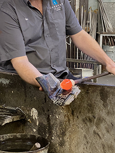 Expert glass blower rolling molten glass Expert glass blower rolling molten glass